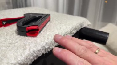 Mobilyaları döşemek, zımba yerleştirmek, mobilyaları yenilemek, kumaşla döşemek için bir zımba tutan döşemeci.