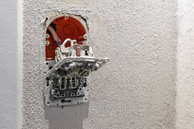 Montaj kutusundaki kablolarla duvardan sarkan hasarlı ışık düğmesi, tamiri değiştir