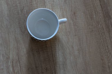 Tahta tezgahta beyaz, boş bir kahve fincanı, üst manzara.