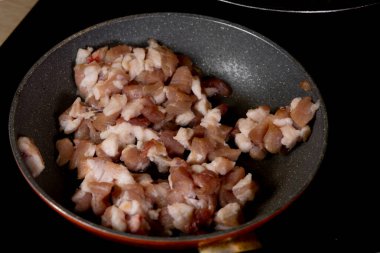 Tavada kızarmış et, tavada domuz pastırması, pierogi için tavada kızartılmış çiğ domuz pastırması, Noel hazırlıkları, gerçekçi bir mutfak fotoğrafı.