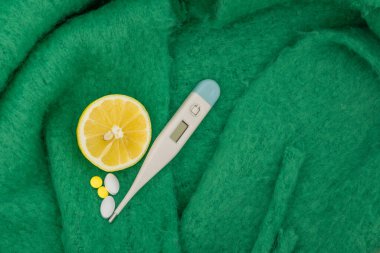 Elektronik termometre, ağrı kesiciler, ateş için parasetamol ilacı, vitaminler, ortadan kesilmiş sarı limon, soğuk algınlığı, grip salgını, gerçekçi iğneler.