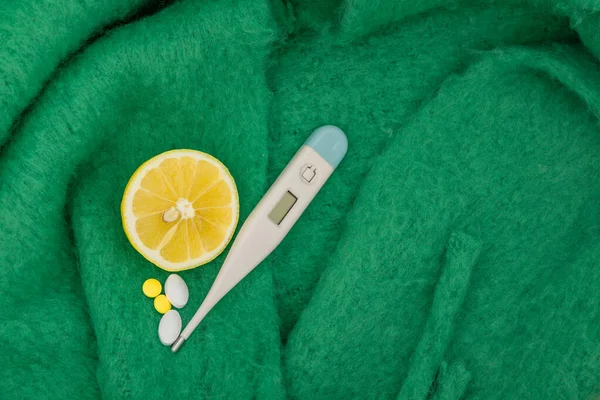 Elektronik termometre, ağrı kesiciler, ateş için parasetamol ilacı, vitaminler, ortadan kesilmiş sarı limon, soğuk algınlığı, grip salgını, gerçekçi iğneler.