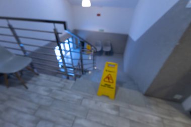 Oteldeki kaygan fayansların sarı bilgi panosu, merdivenlerdeki kaygan zeminin ıslak ve kaygan yüzey hakkında uyarılar.