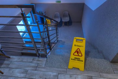 Oteldeki kaygan fayansların sarı bilgi panosu, merdivenlerdeki kaygan zeminin ıslak ve kaygan yüzey hakkında uyarılar.