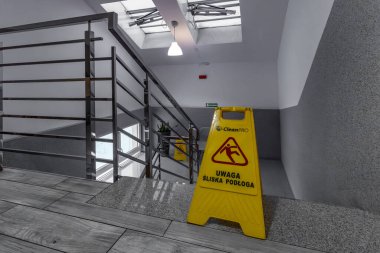 Oteldeki kaygan fayansların sarı bilgi panosu, merdivenlerdeki kaygan zeminin ıslak ve kaygan yüzey hakkında uyarılar.