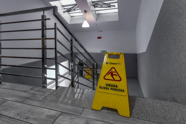 Oteldeki kaygan fayansların sarı bilgi panosu, merdivenlerdeki kaygan zeminin ıslak ve kaygan yüzey hakkında uyarılar.