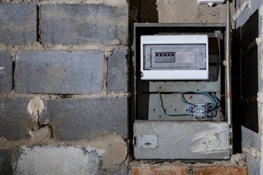 Bodrum duvarındaki eski elektrik sigorta kutusu, eski bir evde elektrik kesintisi, elektrik kesintisi, bozuk elektrik sistemi.