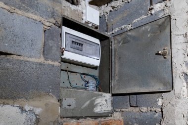 Bodrum duvarındaki eski elektrik sigorta kutusu, eski bir evde elektrik kesintisi, elektrik kesintisi, bozuk elektrik sistemi.