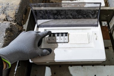 Bodrum duvarındaki eski elektrik sigorta kutusu, eski bir evde elektrik kesintisi, elektrik kesintisi, bozuk elektrik sistemi.