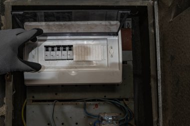 Bodrum duvarındaki eski elektrik sigorta kutusu, eski bir evde elektrik kesintisi, elektrik kesintisi, bozuk elektrik sistemi.