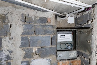 Bodrum duvarındaki eski elektrik sigorta kutusu, eski bir evde elektrik kesintisi, elektrik kesintisi, bozuk elektrik sistemi.