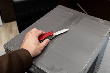 Kuryenin getirdiği paketten Air Fryer 'ı çıkarmak, evdeki mutfakta tavayla birlikte kutuyu açmak.