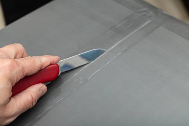 Kuryenin getirdiği paketten Air Fryer 'ı çıkarmak, evdeki mutfakta tavayla birlikte kutuyu açmak.