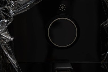 Paketinden çıkartılan siyah bir fritöz mutfak masasının üzerine yerleştirilmiş, bir Air Fryer cihazı, çevrimiçi bir kuryeden sipariş edilen bir mutfak aletinin paketini açıyor.