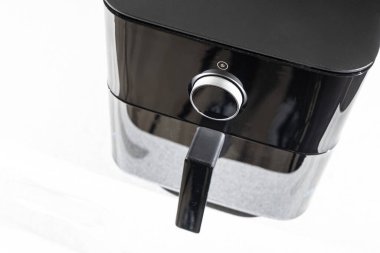 Paketinden çıkartılan siyah bir fritöz mutfak masasının üzerine yerleştirilmiş, bir Air Fryer cihazı, çevrimiçi bir kuryeden sipariş edilen bir mutfak aletinin paketini açıyor.