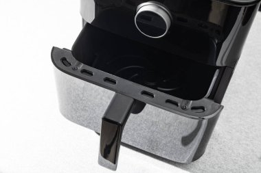 Paketinden çıkartılan siyah bir fritöz mutfak masasının üzerine yerleştirilmiş, bir Air Fryer cihazı, çevrimiçi bir kuryeden sipariş edilen bir mutfak aletinin paketini açıyor.