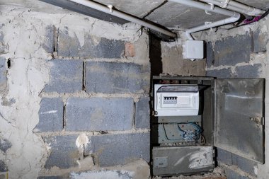 Bodrum duvarındaki eski elektrik sigorta kutusu, eski bir evde elektrik kesintisi, elektrik kesintisi, bozuk elektrik sistemi.