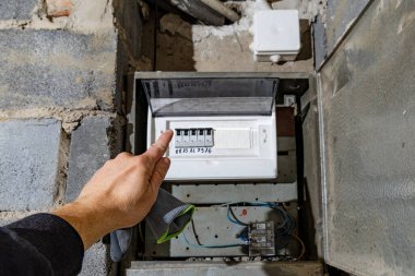 Bodrum duvarındaki eski elektrik sigorta kutusu, eski bir evde elektrik kesintisi, elektrik kesintisi, bozuk elektrik sistemi.