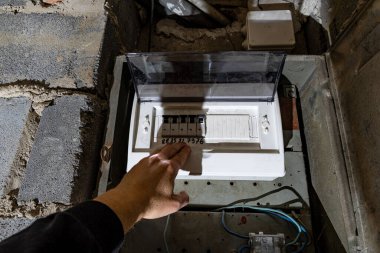 Bodrum duvarındaki eski elektrik sigorta kutusu, eski bir evde elektrik kesintisi, elektrik kesintisi, bozuk elektrik sistemi.