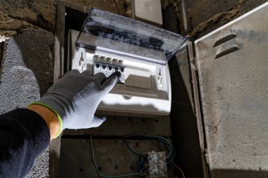 Bodrum duvarındaki eski elektrik sigorta kutusu, eski bir evde elektrik kesintisi, elektrik kesintisi, bozuk elektrik sistemi.