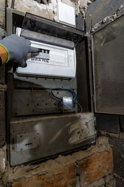 Bodrum duvarındaki eski elektrik sigorta kutusu, eski bir evde elektrik kesintisi, elektrik kesintisi, bozuk elektrik sistemi.