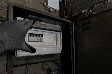 Bodrum duvarındaki eski elektrik sigorta kutusu, eski bir evde elektrik kesintisi, elektrik kesintisi, bozuk elektrik sistemi.