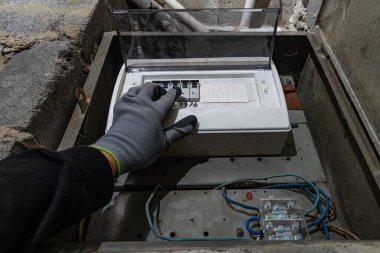 Bodrum duvarındaki eski elektrik sigorta kutusu, eski bir evde elektrik kesintisi, elektrik kesintisi, bozuk elektrik sistemi.