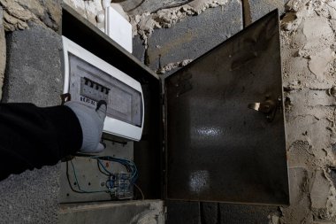 Bodrum duvarındaki eski elektrik sigorta kutusu, eski bir evde elektrik kesintisi, elektrik kesintisi, bozuk elektrik sistemi.