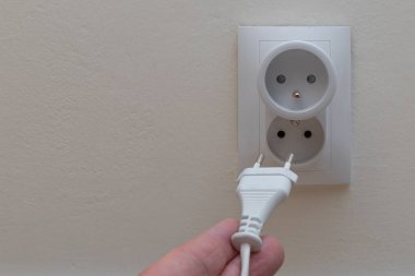 Ahşap zemine kablolu bir fiş, bir telefon tarafından kontrol edilen akıllı bir elektrik prizi, Şeyler İnterneti, uzaktan kumandalı bir elektrik çıkışı.