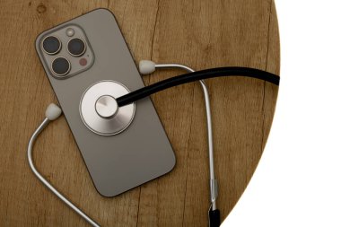 Hasarlı bir cep telefonu ahşap servis masasına yerleştirilmiş, steteskop kulaklıkları, telefon arızası aramak, telefonu kendin tamir etmeye çalışmak, cep telefonu servisi.