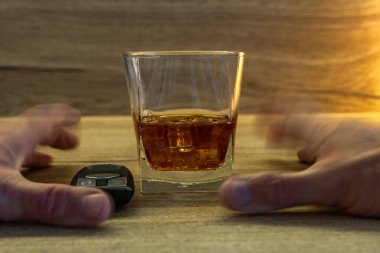 Kör kütük sarhoş bir sürücü, tezgahtan buzlu bir bardak viski almaya çalışır. Alkol yasağı etkisi altında araç kullanırken sürücünün alkolü kötüye kullanması.