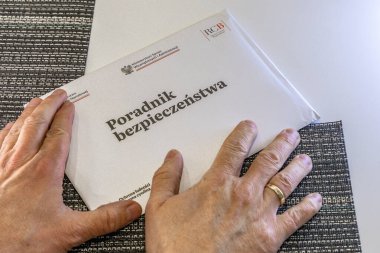 Czestochowa, Polonya, 14 Şubat 2026 - Bir adam Polonya Milli Savunma Bakanlığı tarafından gönderilen bir mektubu açıyor, bir askeri kaza hakkında bir broşür okuyor, bir güvenlik rehberi