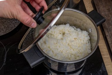 Pirinç sirkesiyle tatlandırılmış pirinç, suşi malzemeleri, tencerede beyaz Çin pirinci, evde suşi yapmak, tipik Japon yemekleri için ev yapımı bir tarif.