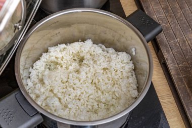 Pirinç sirkesiyle tatlandırılmış pirinç, suşi malzemeleri, tencerede beyaz Çin pirinci, evde suşi yapmak, tipik Japon yemekleri için ev yapımı bir tarif.