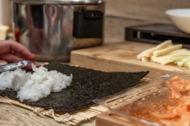 Tahtada dilimlenmiş somon balığı, geleneksel Japon suşisi, evde sağlıklı Çin yemeği hazırlıyor.