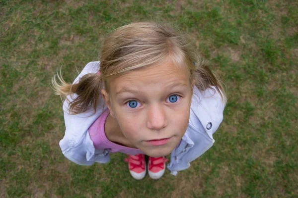 Criança menina rosto de cima perspectiva tiro fora na grama — Fotografia de Stock