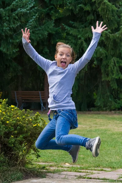 Unga barn flicka hoppande till uttrycka glädje — Stockfoto