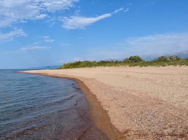 Kırgızistan 'daki Issyk-Kul Gölü' nün kristal mavisi suları boyunca güzel kumlu bir sahil. Yüksek kalite fotoğraf