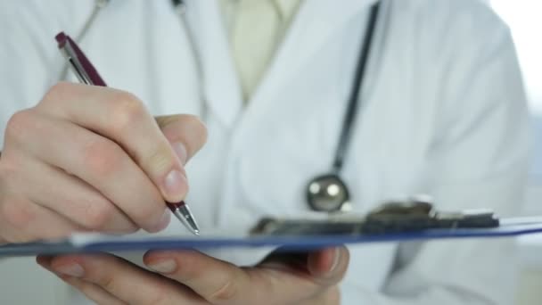 Doctor escribiendo historial médico — Vídeo de stock
