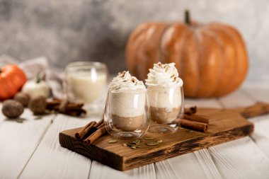 Beton desenli ahşap zemin üzerinde balkabağı ve tarçınlı sıcak ve aromatik latte, boşluğu kopyala.