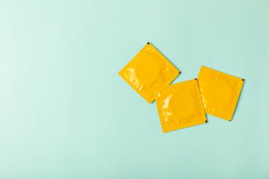 Renkli arka planda prezervatifler. Paketlemede renkli meyve temalı prezervatifler. Güvenli seks konsepti. Doğum kontrol hapı. Farklı doğum kontrol yöntemleri. AİDS önleme. Dünya AIDS Günü. Cinsel sağlık.