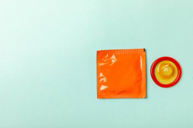 Renkli arka planda prezervatifler. Paketlemede renkli meyve temalı prezervatifler. Güvenli seks konsepti. Doğum kontrol hapı. Farklı doğum kontrol yöntemleri. AİDS önleme. Dünya AIDS Günü. Cinsel sağlık.