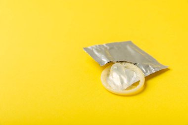 Renkli arka planda prezervatifler. Paketlemede renkli meyve temalı prezervatifler. Güvenli seks konsepti. Doğum kontrol hapı. Farklı doğum kontrol yöntemleri. AİDS önleme. Dünya AIDS Günü. Cinsel sağlık.