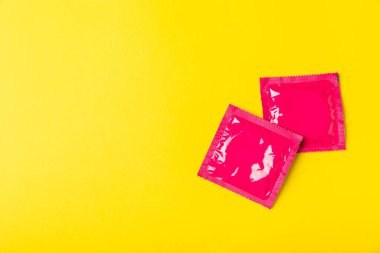 Renkli arka planda prezervatifler. Paketlemede renkli meyve temalı prezervatifler. Güvenli seks konsepti. Doğum kontrol hapı. Farklı doğum kontrol yöntemleri. AİDS önleme. Dünya AIDS Günü. Cinsel sağlık.