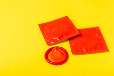 Renkli arka planda prezervatifler. Paketlemede renkli meyve temalı prezervatifler. Güvenli seks konsepti. Doğum kontrol hapı. Farklı doğum kontrol yöntemleri. AİDS önleme. Dünya AIDS Günü. Cinsel sağlık.