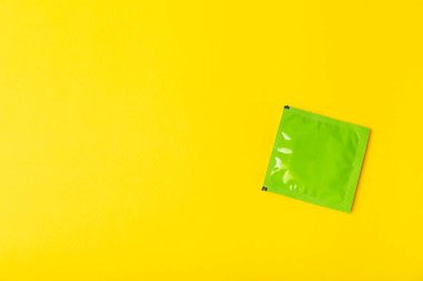 Renkli arka planda prezervatifler. Paketlemede renkli meyve temalı prezervatifler. Güvenli seks konsepti. Doğum kontrol hapı. Farklı doğum kontrol yöntemleri. AİDS önleme. Dünya AIDS Günü. Cinsel sağlık.