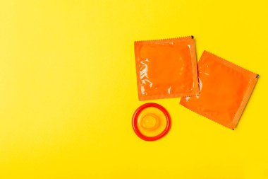 Renkli arka planda prezervatifler. Paketlemede renkli meyve temalı prezervatifler. Güvenli seks konsepti. Doğum kontrol hapı. Farklı doğum kontrol yöntemleri. AİDS önleme. Dünya AIDS Günü. Cinsel sağlık.