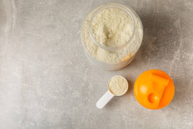 Protein karışımı ve renkli bir arka planda protein tozu. Toz su veya sütle karıştırılır. Dengeli bir diyet için diyet takviyesi. Beyaz protein. Fitness ve jimnastik diyeti.