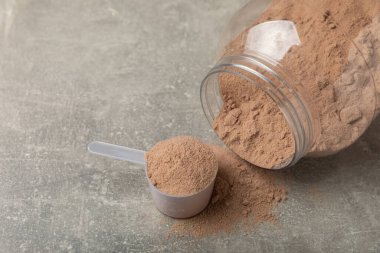 Protein powder. A spoonful of protein powder on a table. Different flavors of whey protein powder. Sports nutrition concept. Gym. Amino acid food supplement, creatine powder. Copy space.