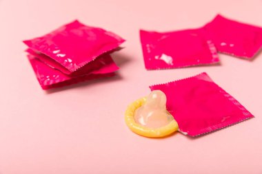 Renkli arka planda prezervatifler. Paketlemede renkli meyve temalı prezervatifler. Güvenli seks konsepti. Doğum kontrol hapı. Farklı doğum kontrol yöntemleri. AİDS önleme. Dünya AIDS Günü. Cinsel sağlık.